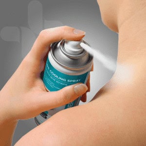 Spray of first aid cooling spray for sports injuries on athlete's shoulder.